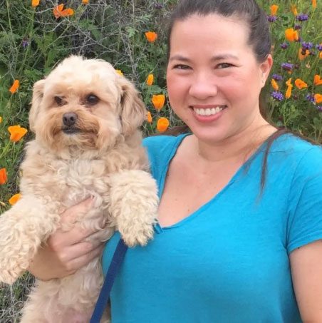 samantha jennings dvm smiling and holding a small dog