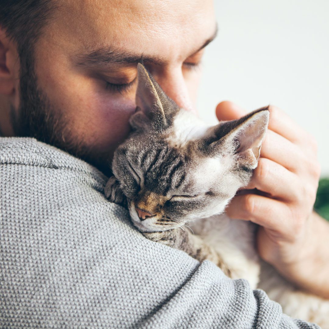 close up of man hugging his cat